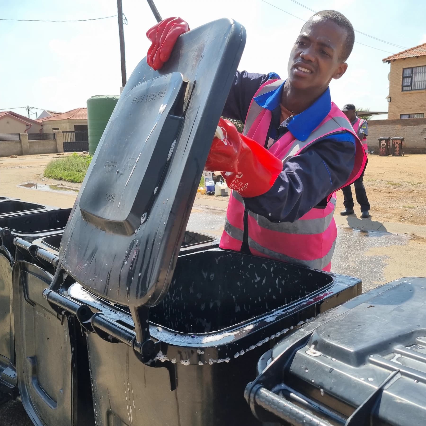 MaT team member washing a wheelie bin during a neighbourhood service